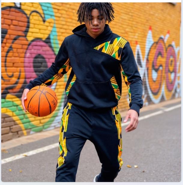 Person holding a basketball in front of a colorful graffiti wall.