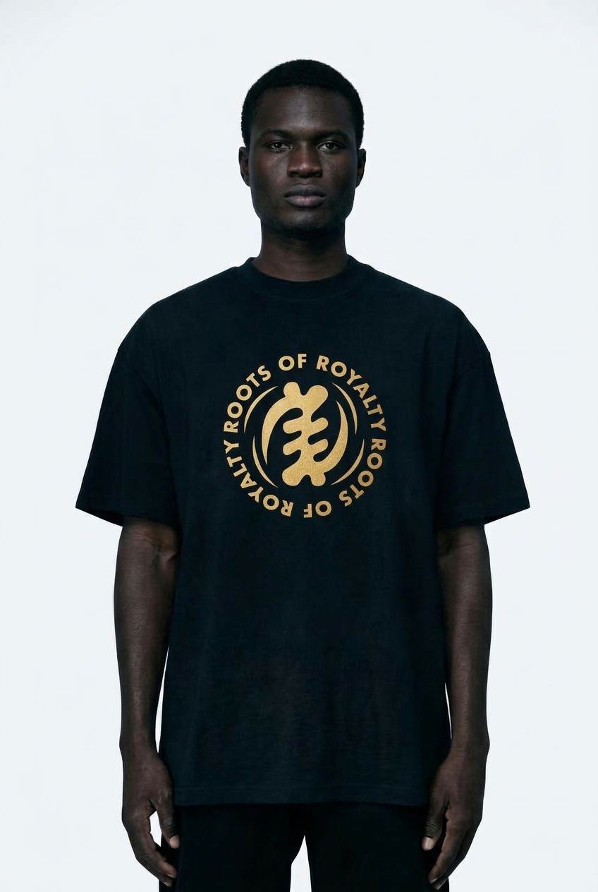 Man wearing a black t-shirt with gold logo and text on a black  background